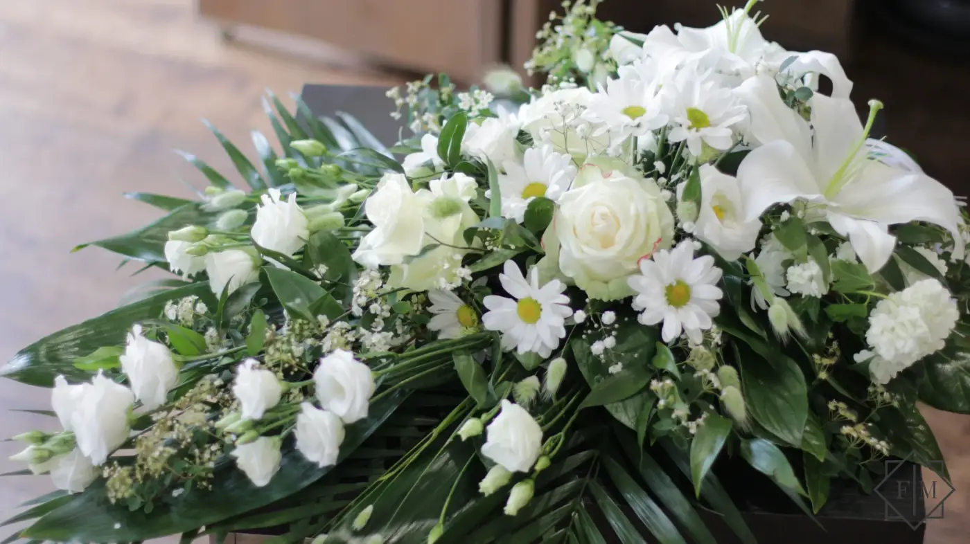 Klasszikus kialakítású sírcsokor fehér színű vegyes virágokkal, örök zöldekkel és vízutánpótlással növényeknek. A búcsú személyesebbé tehető, ha kegyeleti csokorba kéred elhunyt kedvenc virágait.