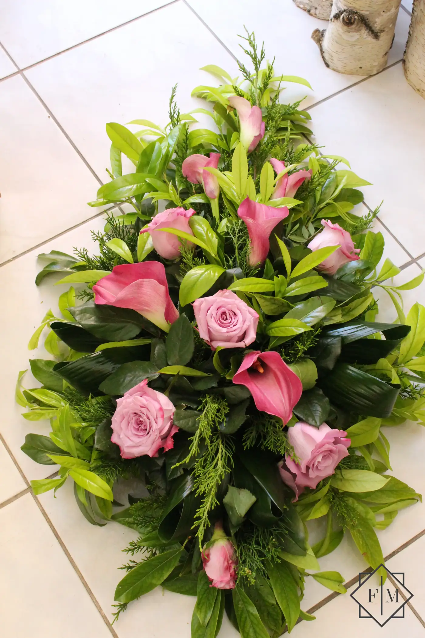 Klasszikus kialakítású sírcsokor mályva színű virágokkal, örök zöldekkel és vízutánpótlással növényeknek. A búcsú személyesebbé tehető, ha kegyeleti csokorba kéred elhunyt kedvenc virágait.