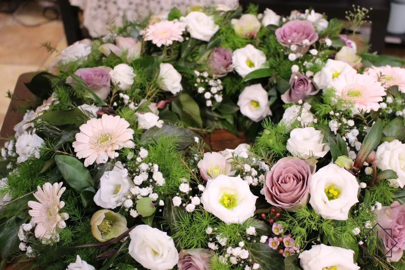 Klasszikus görög koszorú fehér, púder, lila színekben.  Segítünk Neked, hogy a búcsú a lehető legszebb és legszemélyesebb legyen. Mond el nekünk, milyen ember volt az elhunyt, mit szeretett, hogyan élt. Mi gondoskodunk róla, hogy ez kifejeződjék a virágkompozíciókban.