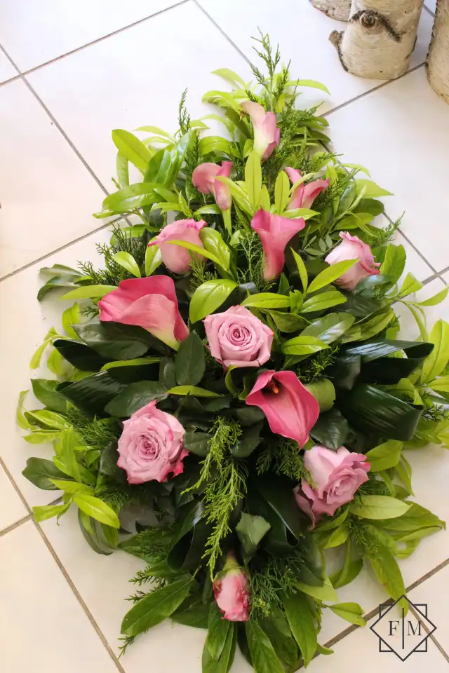 Klasszikus kialakítású sírcsokor mályva színű virágokkal, örök zöldekkel és vízutánpótlással növényeknek. A búcsú személyesebbé tehető, ha kegyeleti csokorba kéred elhunyt kedvenc virágait.